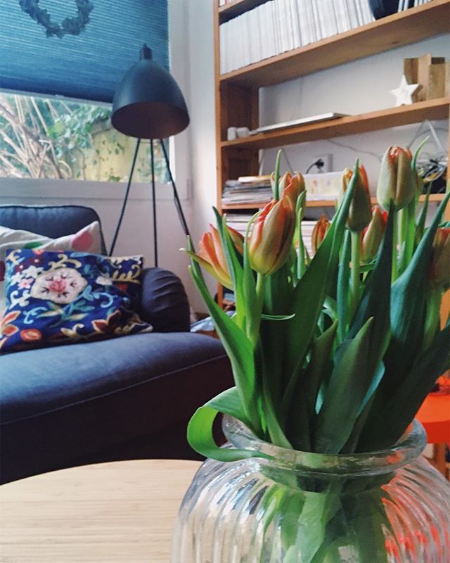 Tulpen in einer Vase stehen auf einem Couchtisch in einem Wohnzimmer
