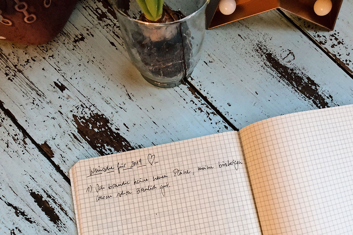 Ein aufgeschlagenes Notizbuch mit dem Satz "Ich brauche keine neuen Pläne, meine bisherigen waren schon ziemlich gut.