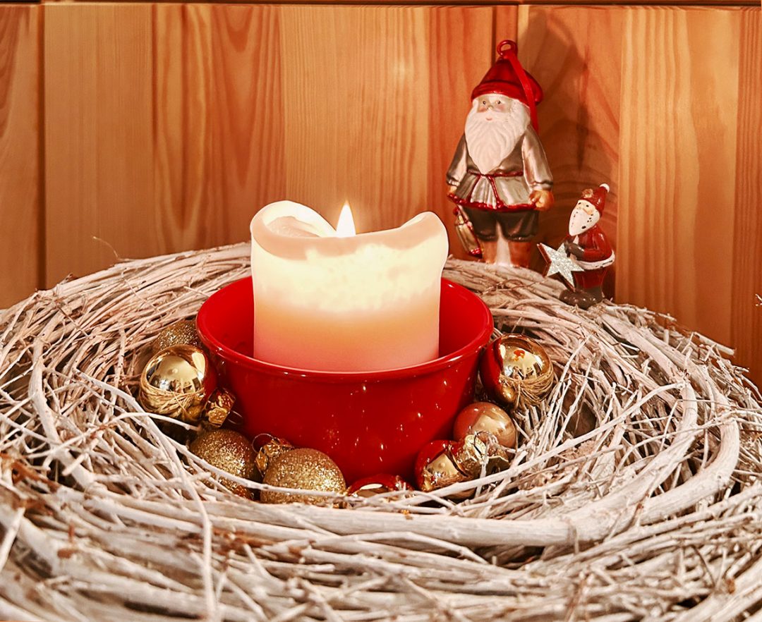 Ein minimalistischer Adventskranz mit Kerze und Nikolausfiguren